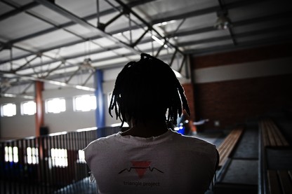 a silhouette of a figure wearing a t-shirt that says "Triangle Project"