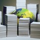 A globe sitting on a surface, partially obscured by stacks of white paper