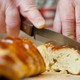 Joan Nathan cuts pain petri, a flavored challah.