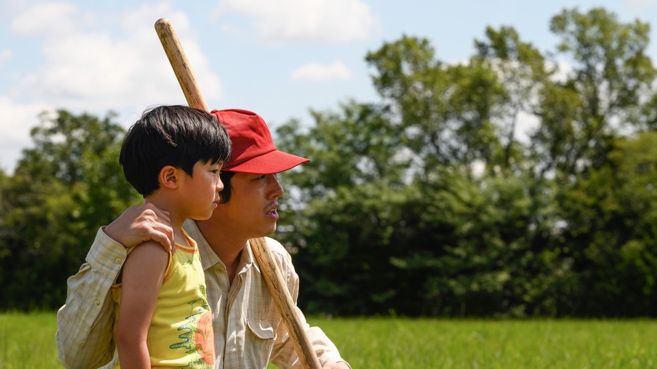 Alan Kim and Steven Yeun in a green field in 'Minari'