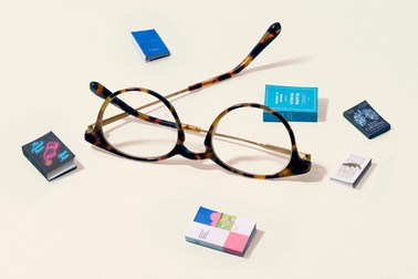 A pair of glasses with tiny books surrounding them