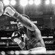 boxer making a left jab in the ring with bright lights and arena behind him