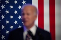 Blurry picture of Biden, the American flag in the background