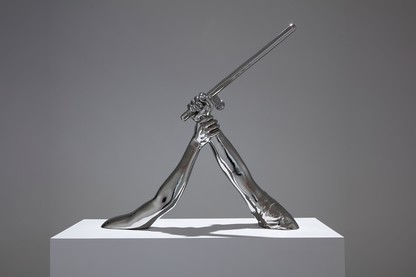 A photo of 'Strike' (2018) by Hank Willis Thomas: a sculpture of one arm holding another arm with a baton