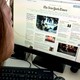 A woman reads The New York Times on her computer