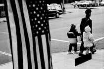 a mother and children walking in front of an American flag