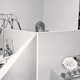 black and white photo of office cubicles with a female office worker's head visible in the back over the cubicle walls