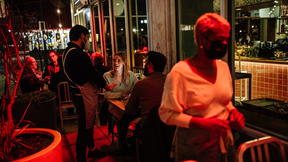 A waiter and d​iners at a restaurant in Austi​n, Texas, in January 2022