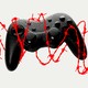 A black video-game controller wrapped in red barbed wire.