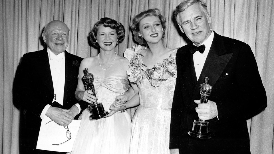 Oscar winners Clair Trevor and Walter Huston, holding their statuettes, pose with last year's winners Edmund Gwenn, far left, and Celeste Holm at the 1948 Academy Awards presentations in Hollywood, Ca., March 24, 1949.