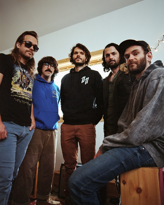 The five members of the band Goose pose for a portrait in their studio.