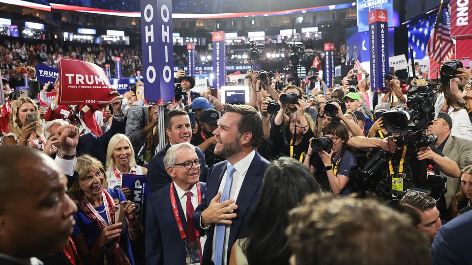 J. D. Vance standing next to the "Ohio" sign and surrounded by a crowd of Trump supporters and press at the Republication National Convention