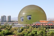 A huge dome, covered in LED lights, displays the eyes and mouth of an emoji face.
