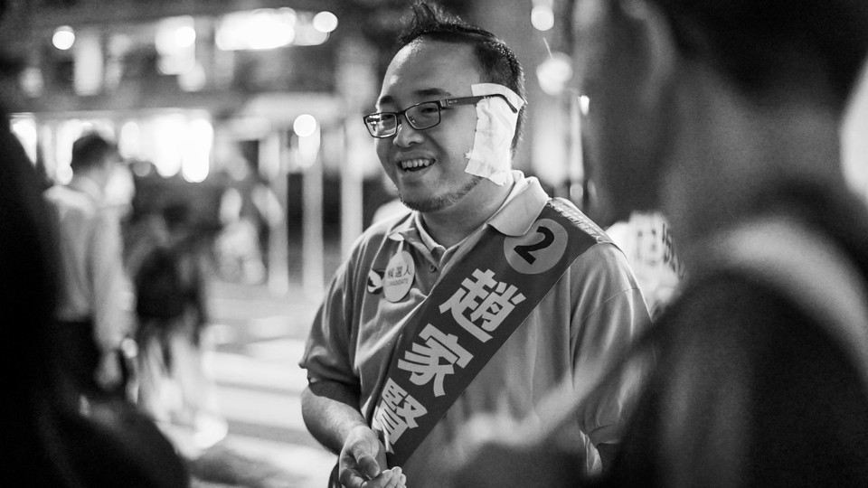 Pro-democracy district-council candidate Andrew Chiu, who was attacked by a man who bit off part of his ear in early November, canvasses on the street during the district council elections in Tai Koo Shing District Council in Hong Kong on November 24, 2019.