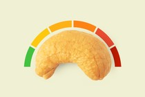 A cashew with a rating system curving above it, ranging from green to red.