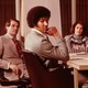 A photograph of workers gathered in a conference room