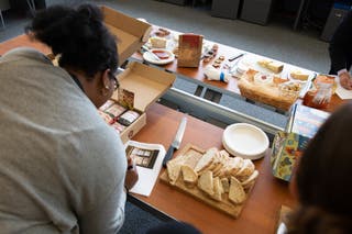 A tester leans over a table of gift basket samples, making notes about Rancho Gordo dried beans.