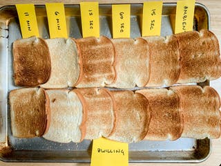 Two parallel rows of toast, with yellow flags marking the length of time each batch was toasted plus a label marking the Zwilling brand.