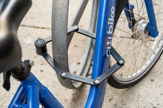 A bike locked to a circular, metal object with the Kryptonite Keeper 585.