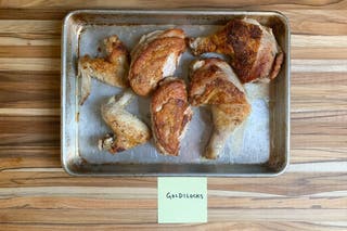 A sheet pan with pieces of chicken browned and cooked in the Goldilocks 12-inch skillet.