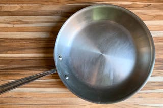 Top view of a used All-Clad D3 Stainless Fry Pan, showing some scratches.