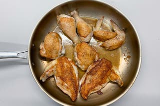 Browned pieces of a whole chicken in the Tramontina skillet.