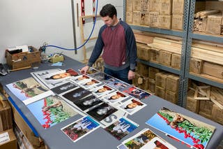 Someone laying out copies of photos on a table.