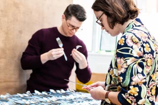 Two of our kitchen testers setting out and examining cutlery.