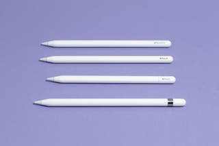 Four Apple pencils lined up horizontally on a purple surface.