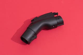 The Lectron’s NACS-to-J1772 adapter on display in front of a red background.