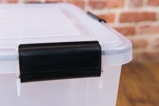 The handle latches of a clear storage container.