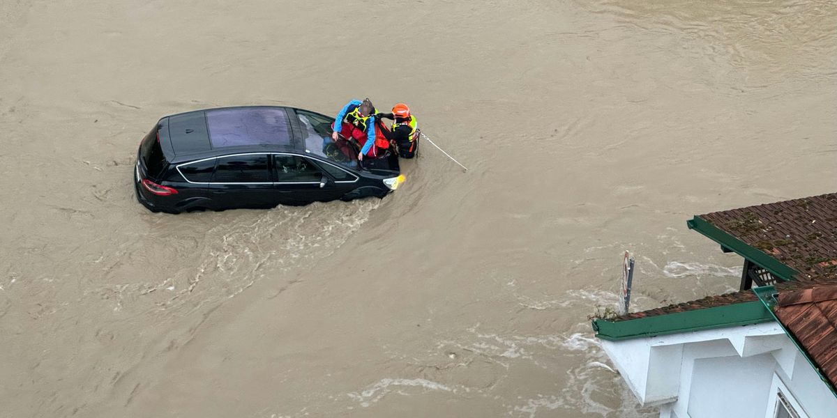 Feuerwehrleute und ein Feuerwehrtaucher retten eine Person aus einem überfluteten Auto in Melk, Österreich, am 15. September 2024.