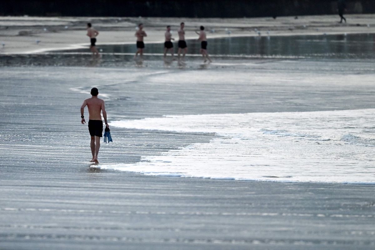 Ein Mann geht nach einem morgendlichen Schwimmen an einem Wintertag am berühmten Bondi Beach in Sydney am 1. August 2024 zurück. (Foto von Saeed KHAN / AFP)