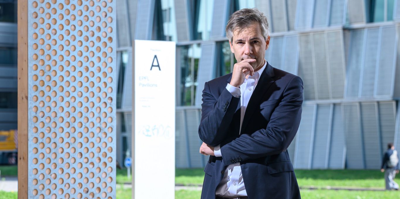 Marcel Salathé steht nachdenklich vor einem modernen Gebäude auf dem Campus der EPFL in Lausanne, 6. September 2024.