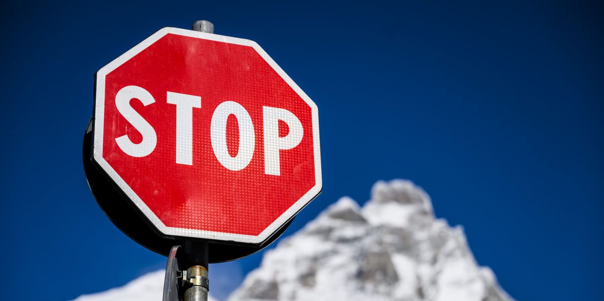 A "Stop" sign is pictured front of the Matterhorn/Cervino mountain from Cervinia area as the women's downhill training race on the new ski course "Gran Becca" was cancelled due to weather conditions and strong wind at the Alpine Skiing FIS Ski World Cup, between Zermatt in Switzerland and Cervinia in Italy, Wednesday, November 15, 2023. (KEYSTONE/Jean-Christophe Bott)