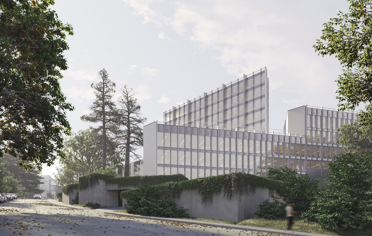 Bâtiment moderne en verre et acier au milieu de la verdure par une journée ensoleillée.