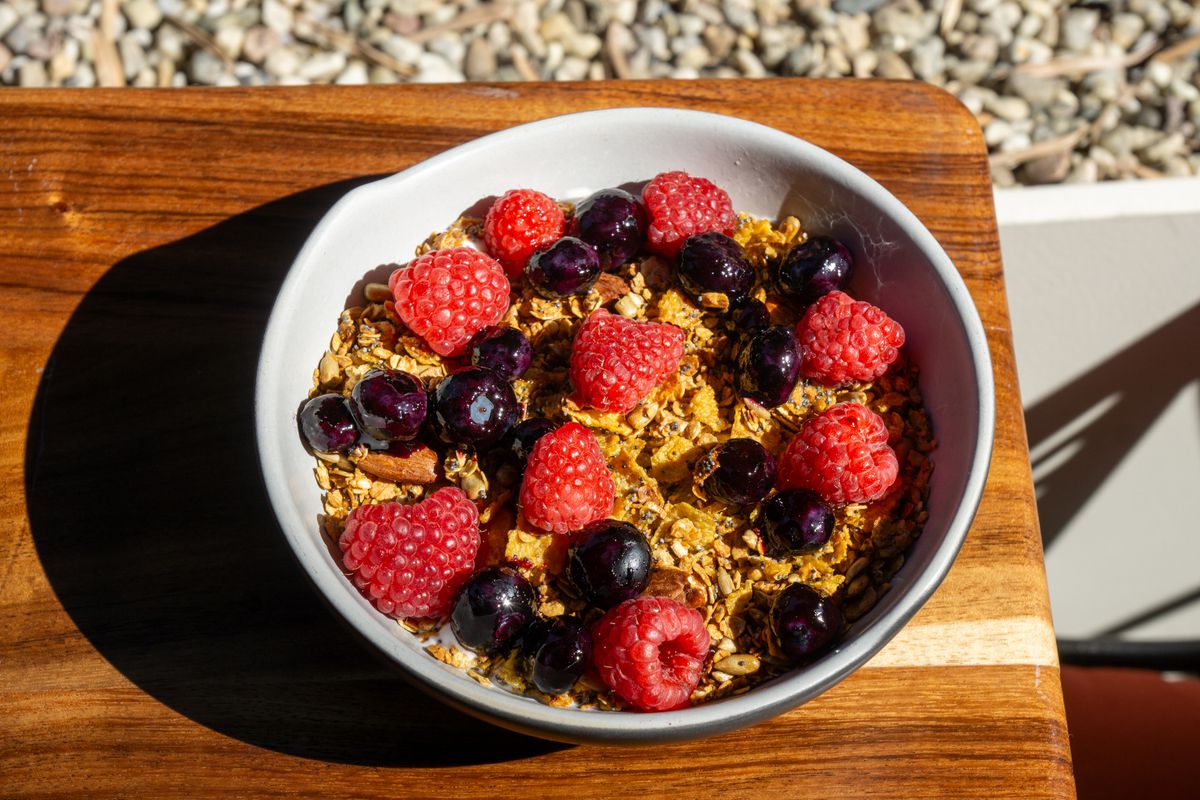 A bowl of berries with granola.