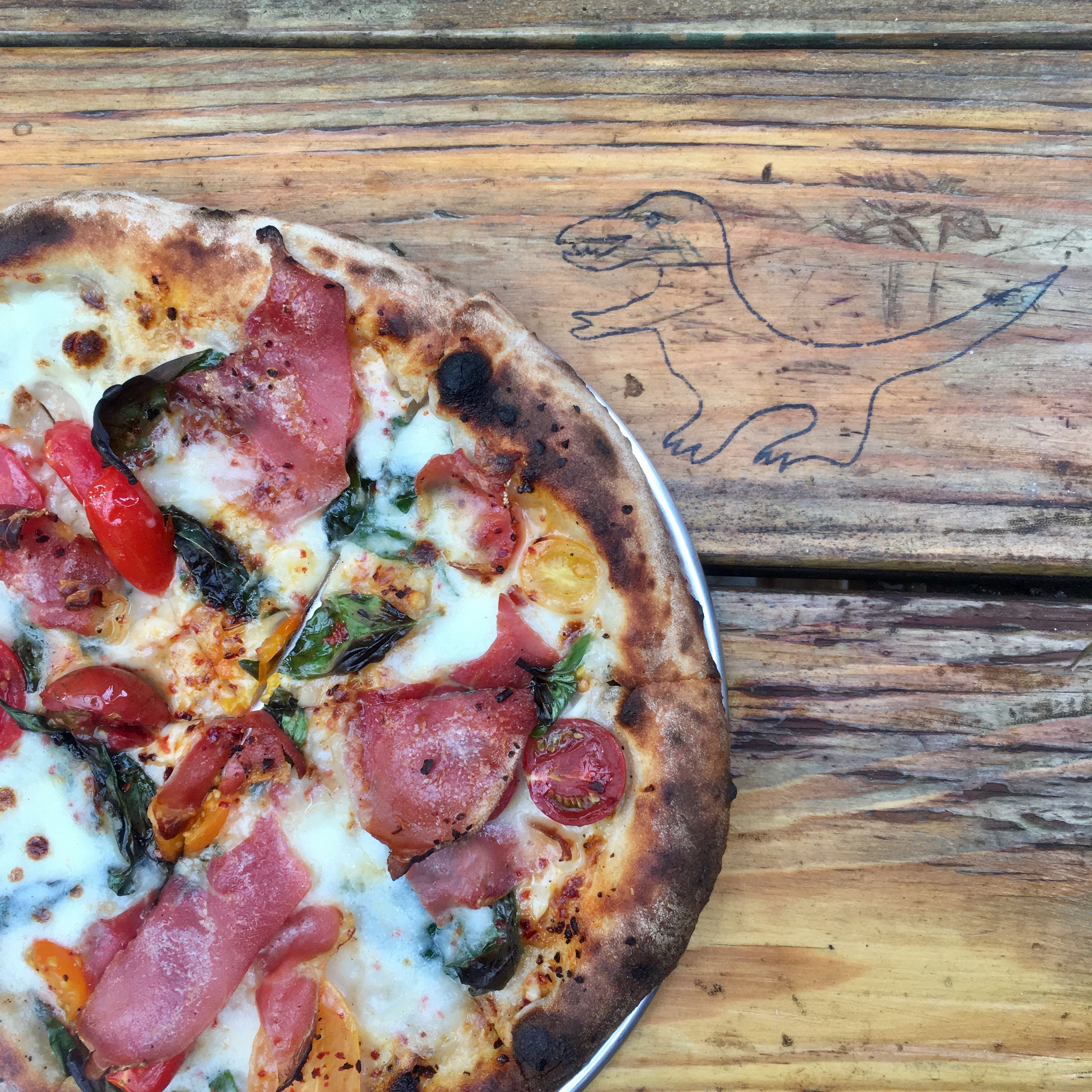 A picture of a country ham pizza with cherry tomatoes and aleppo pepper at Gracie’s Apizza in St. Johns