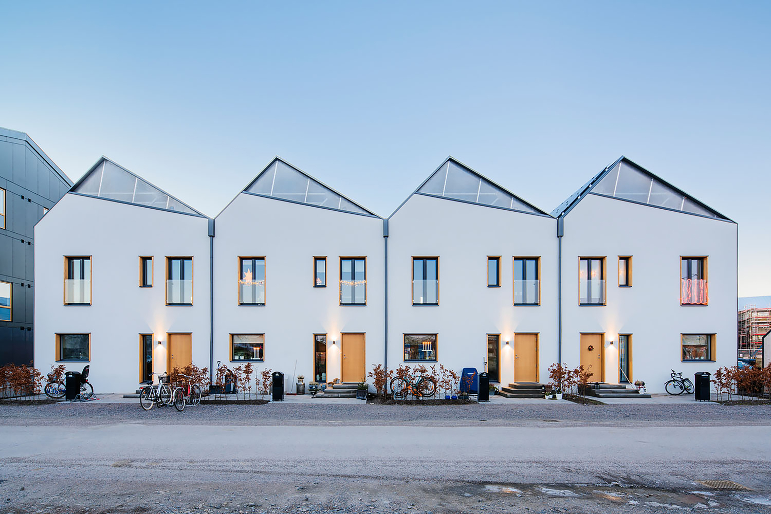 Row of white houses with peaked roofs. 