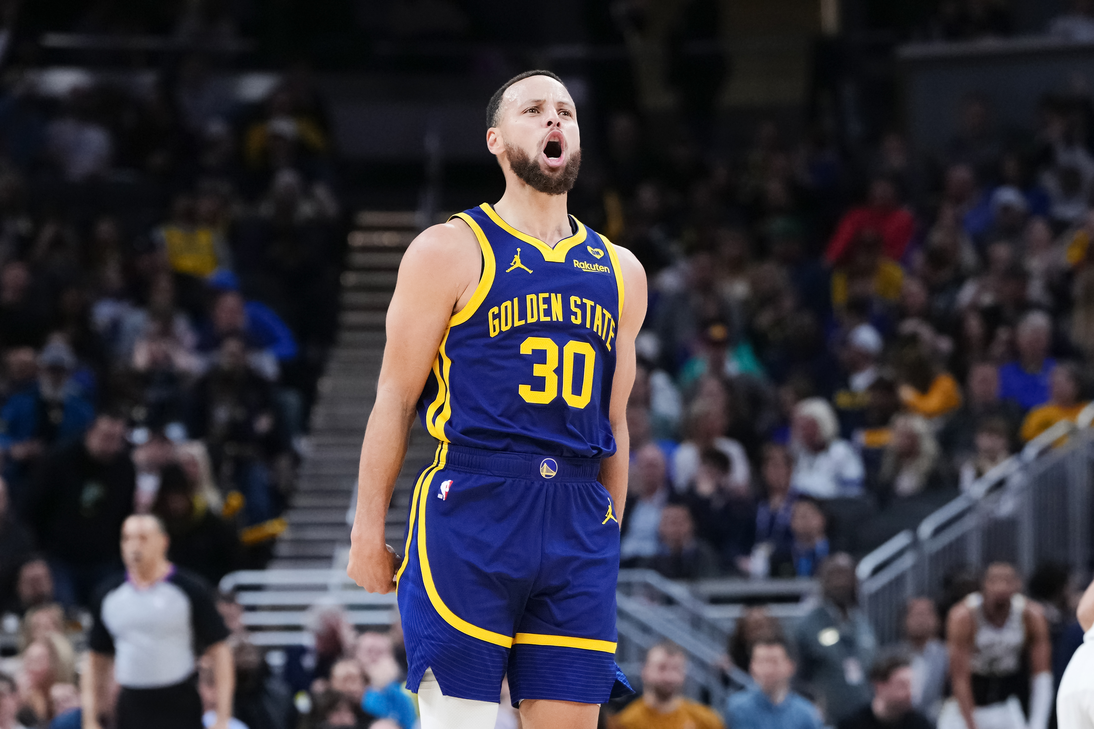 Steph Curry with his arms down, yelling in celebration.