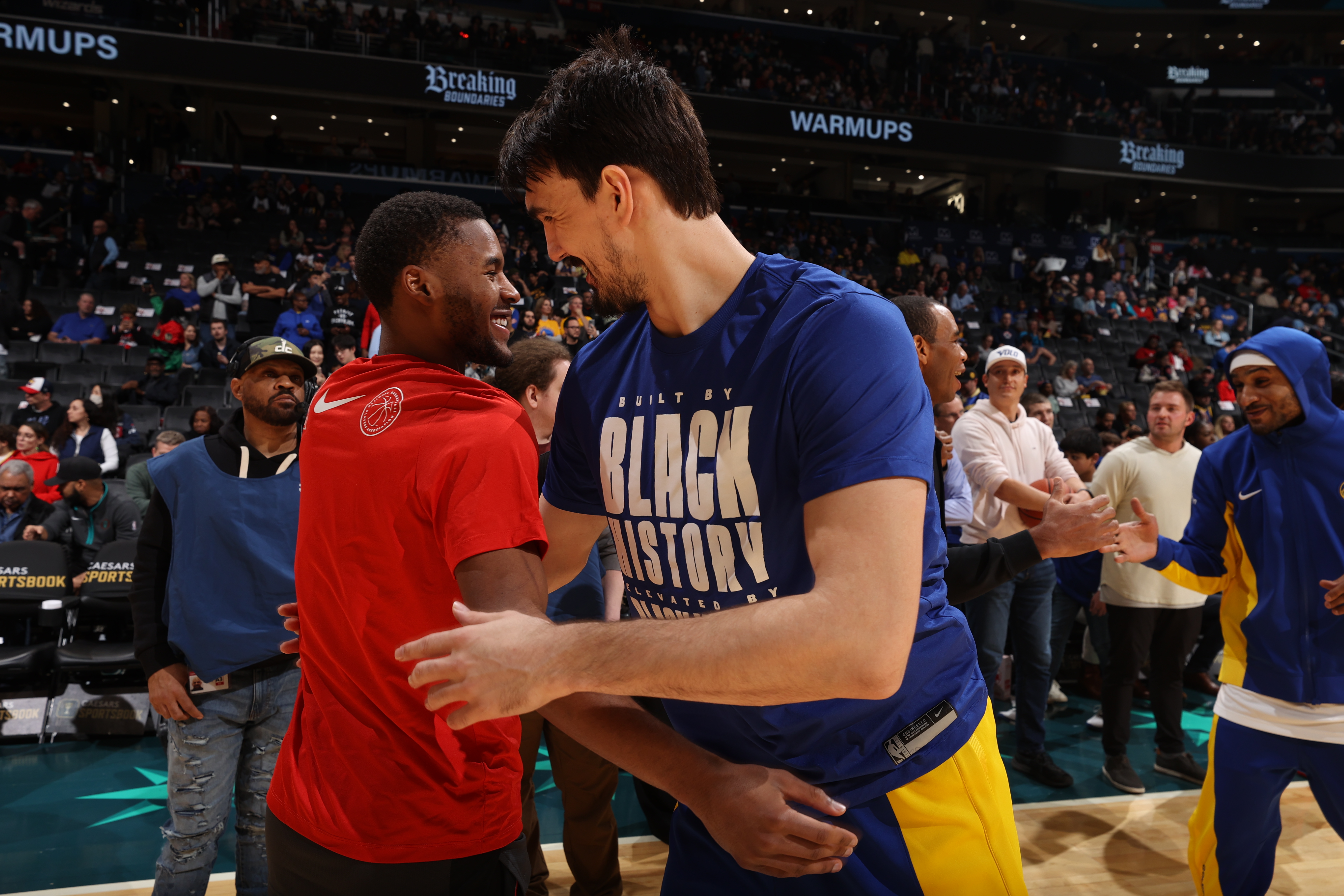 Jared Butler embraces Dario Saric after the game on February 27, 2024 at Capital One Arena in Washington, DC. Dario is wearing a blue Black History Month shirt.