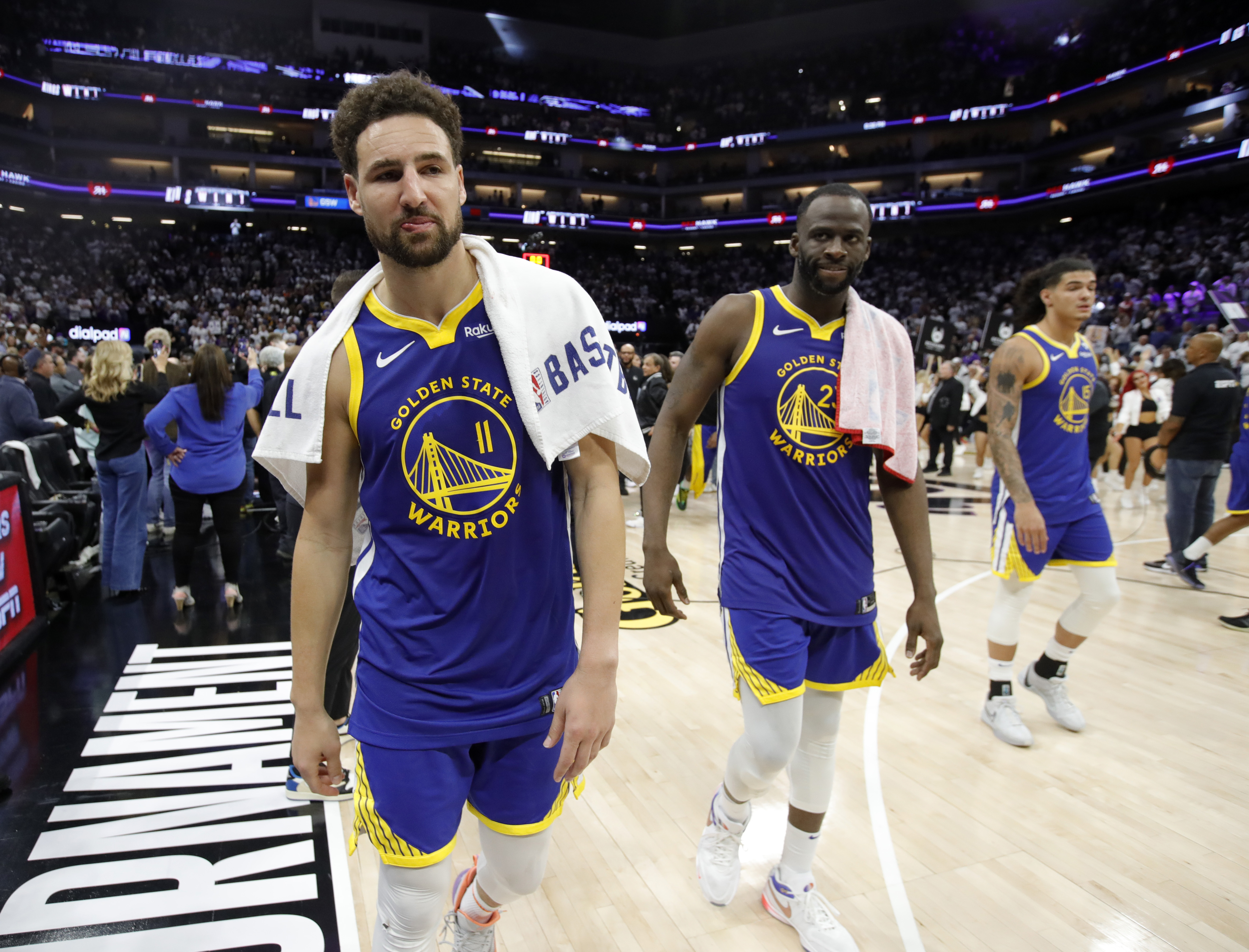 Klay Thompson walking off the court, with Draymond Green behind him. 