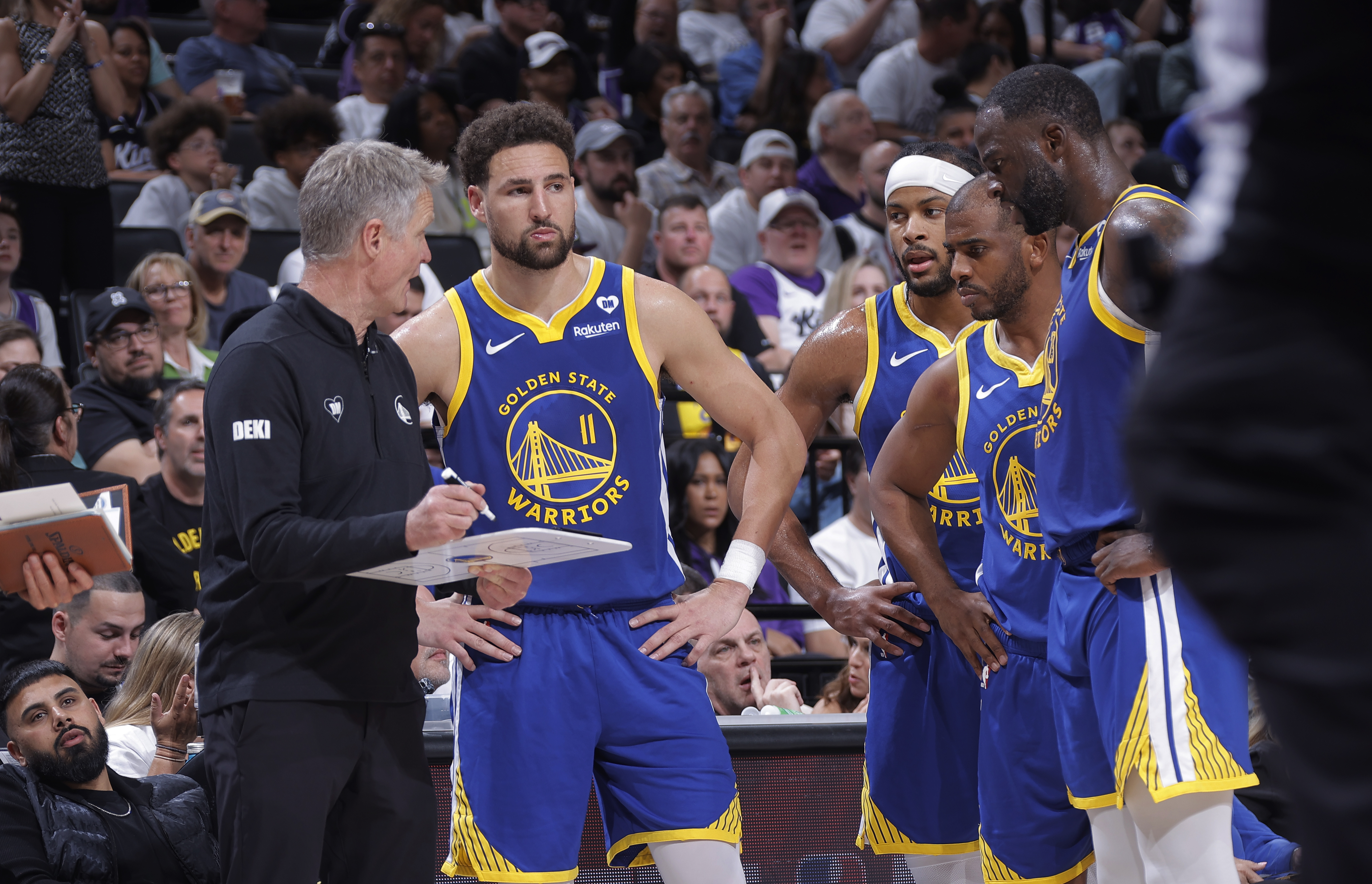 Steve Kerr talking to Klay Thompson, Chris Paul, and Moses Moody. 