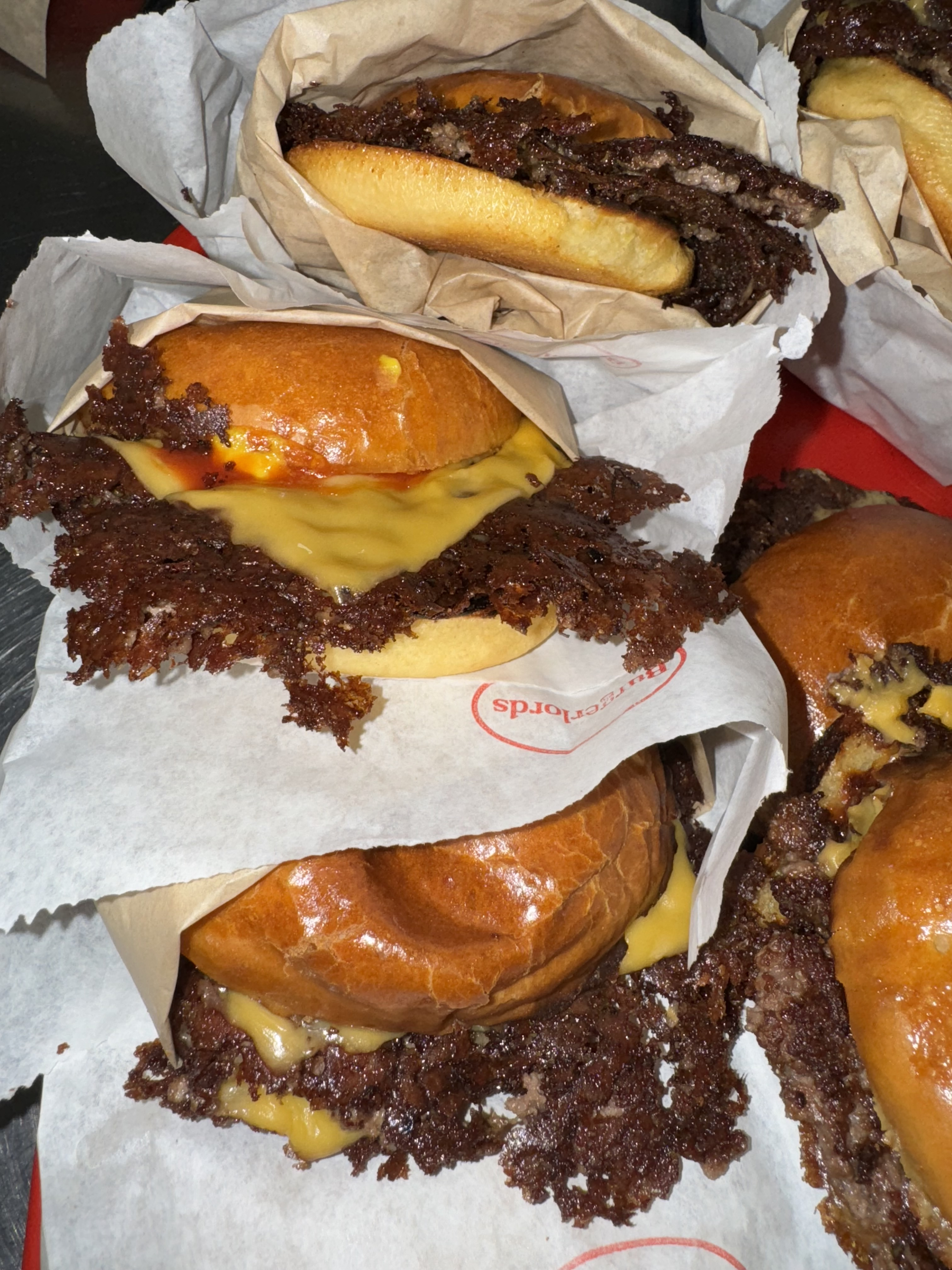 All-new smash burgers at Burgerlords wrapped in white parchment paper.