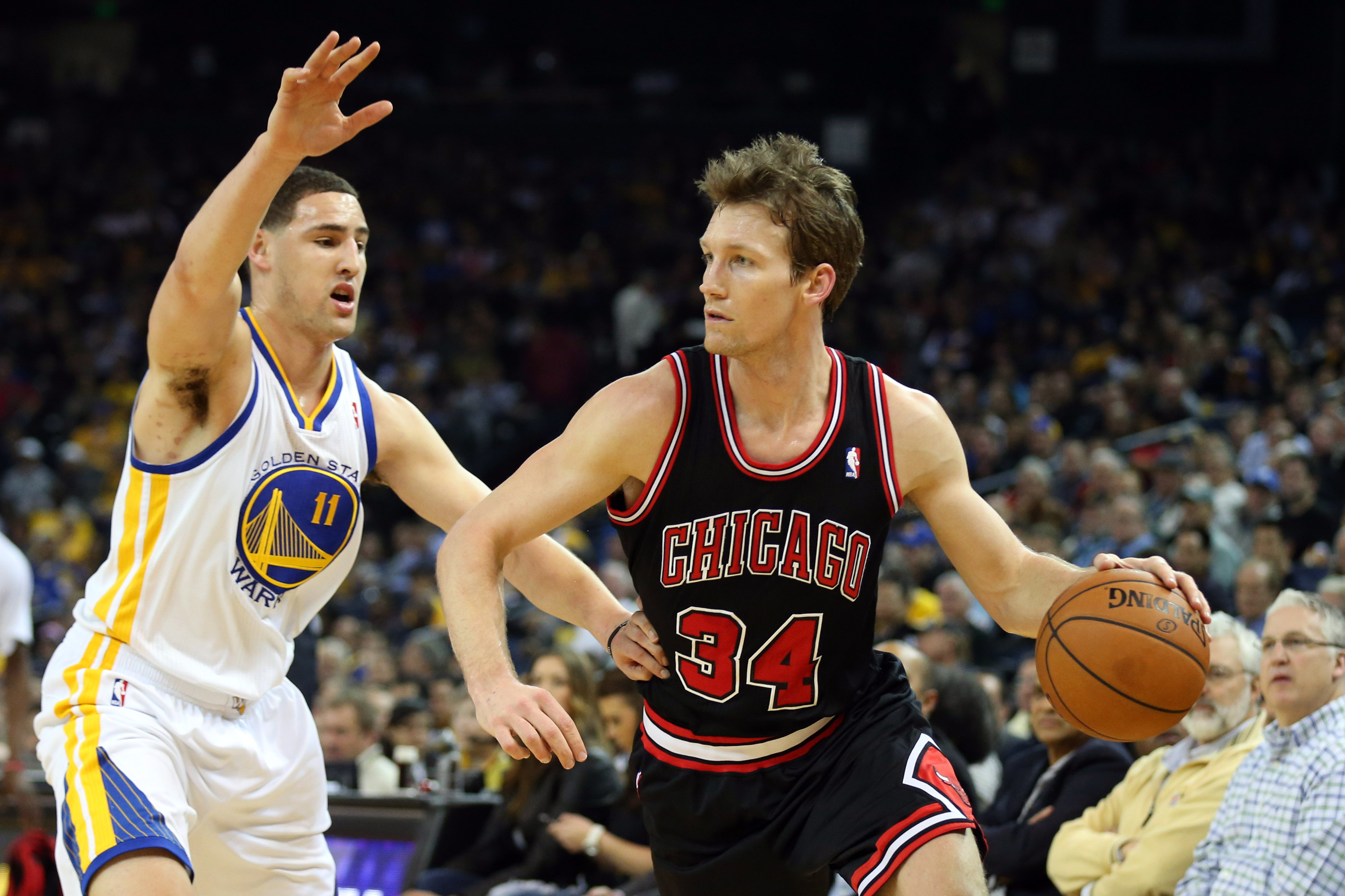 Mike Dunleavy Jr. in a Bulls jersey driving with his left hand past Klay Thompson. 