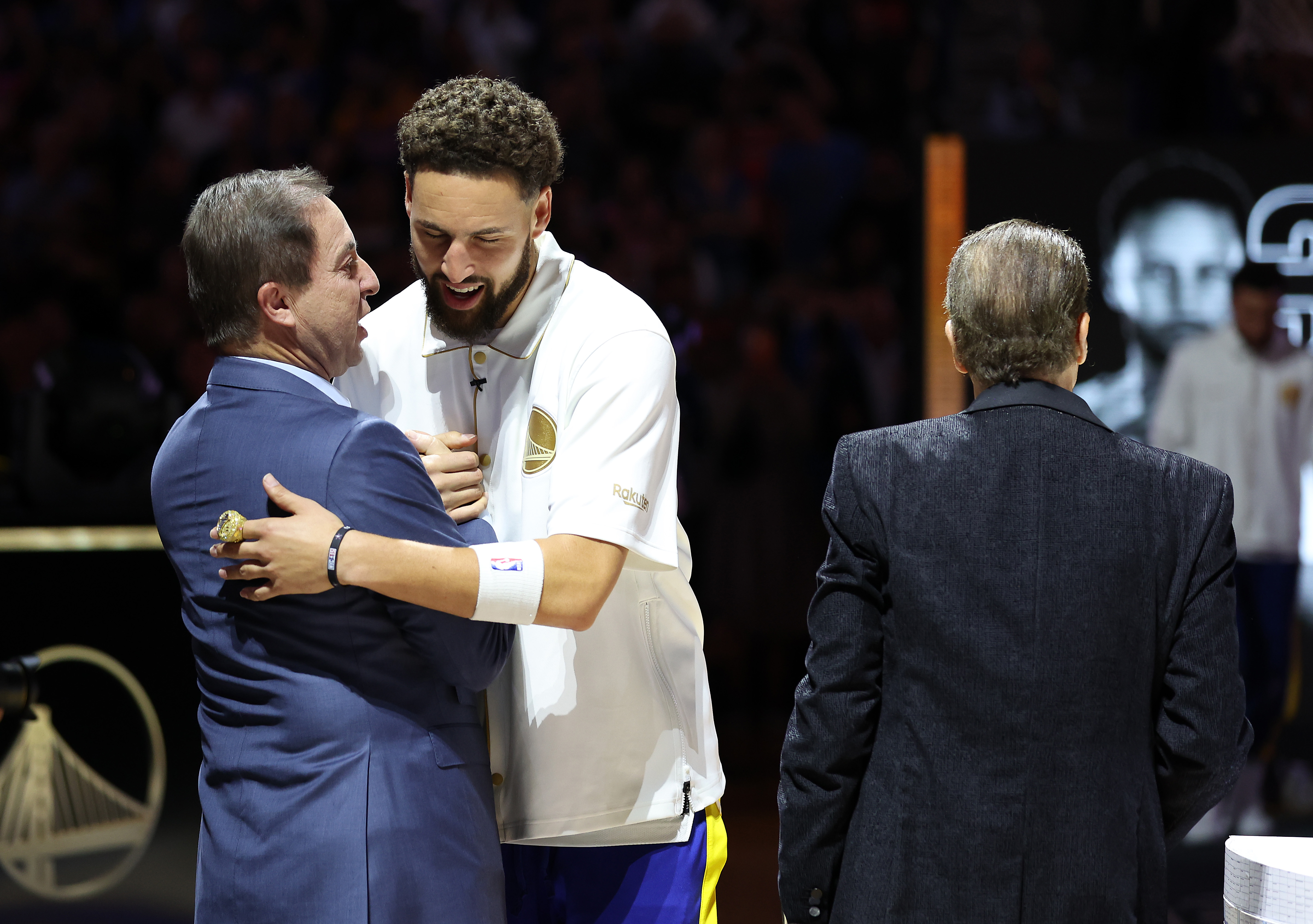 Klay Thompson hugging Joe Lacob at a championship presentation.