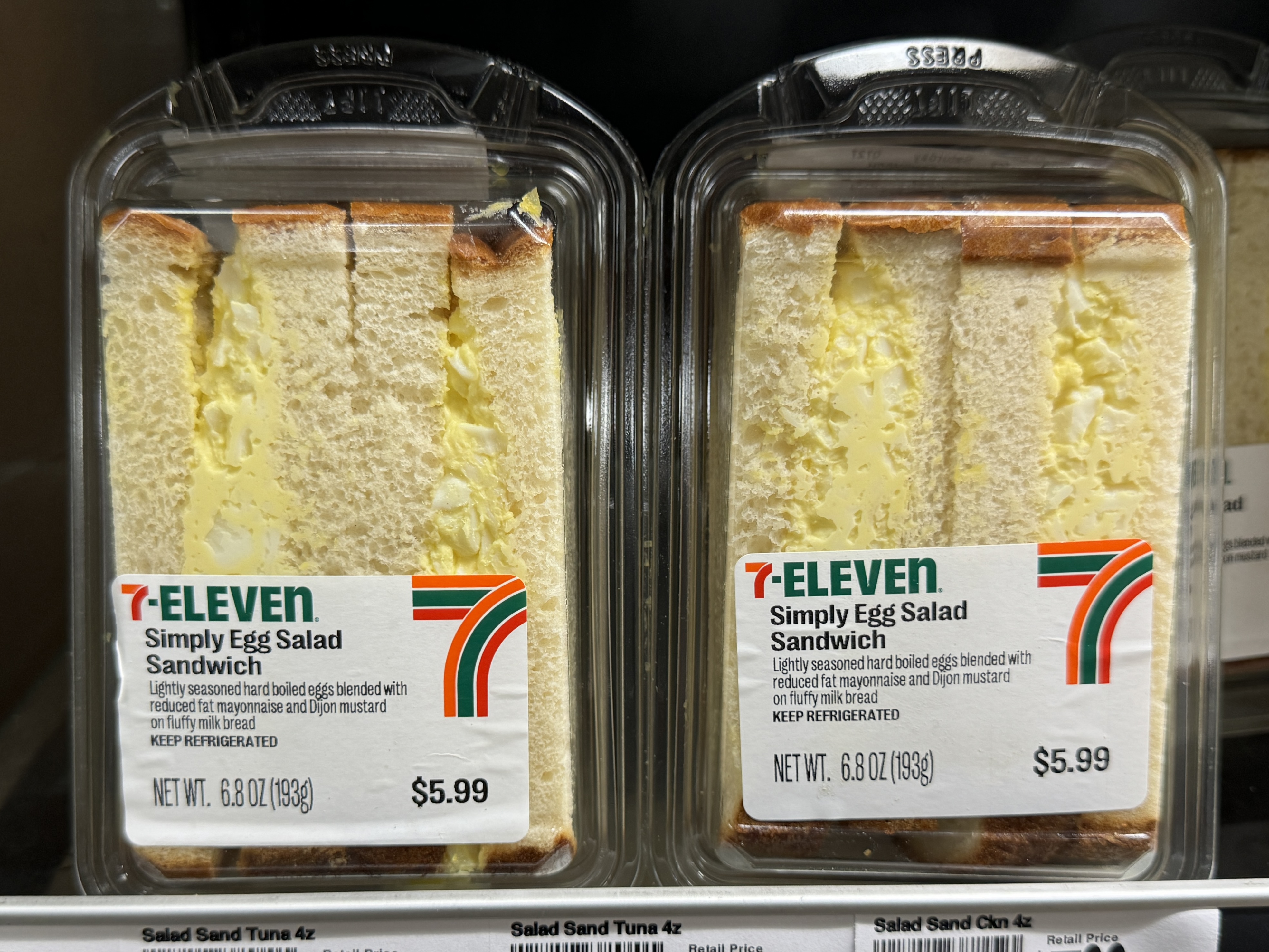 Two egg sandwiches from 7-Eleven in plastic packages on the shelf at 7-Eleven.