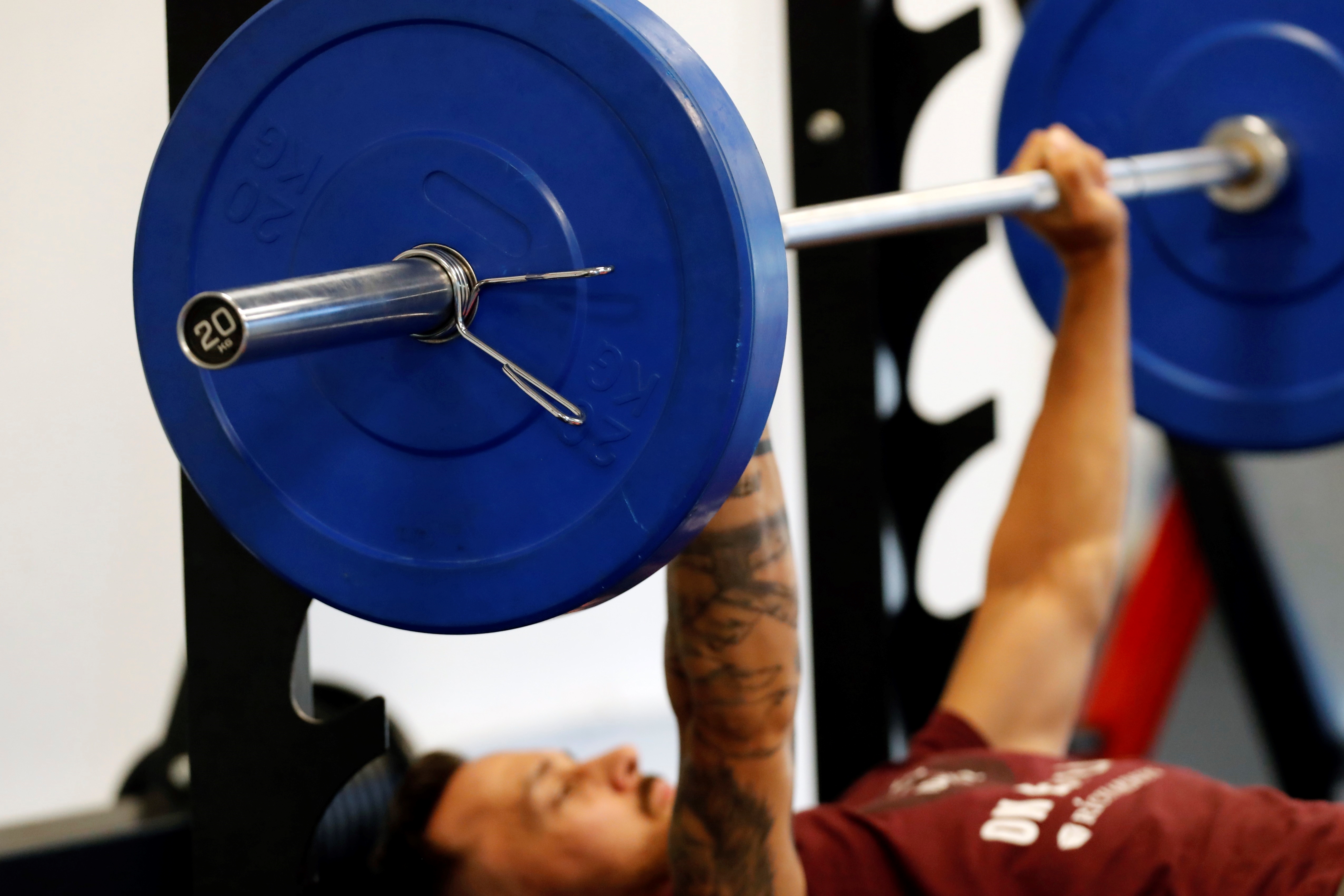 Man lifting weights in gym. France.