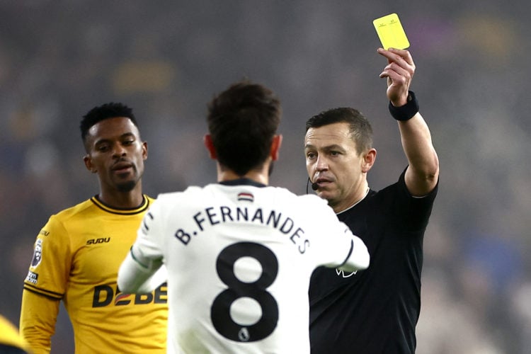 Referee Tony Harrington shows a yellow card to Manchester United's Portuguese midfielder #08 Bruno Fernandes during the English Premier League foot...