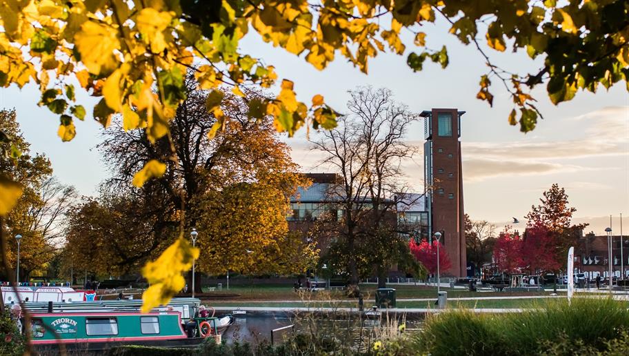 view of the Royal Shakespeare Theatre from Bancroft Gardens, with autumn leaves